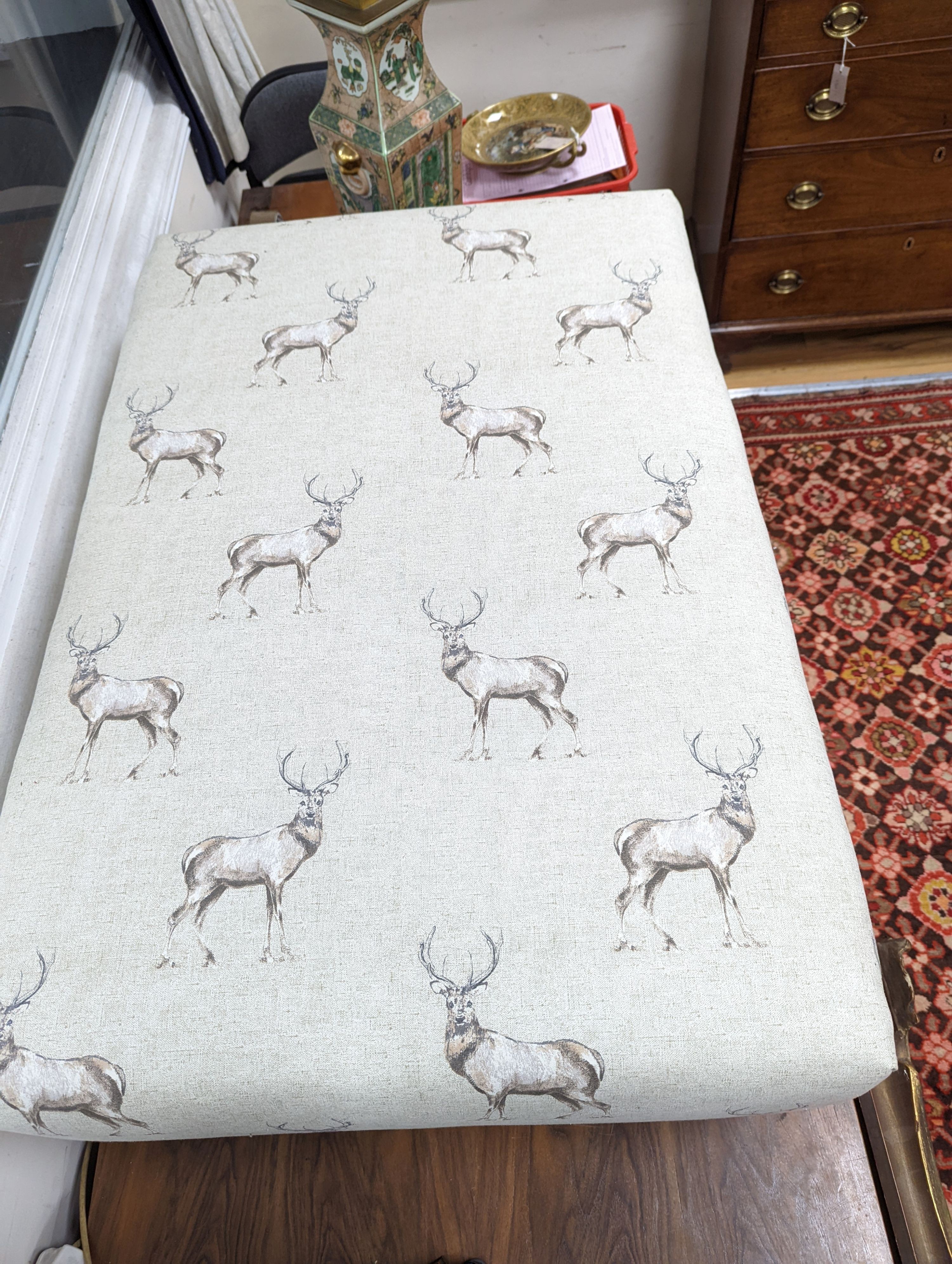 A large contemporary rectangular footstool / coffee table upholstered in stag print fabric on turned beech feet, length 107cm, depth 72cm, height 38cm